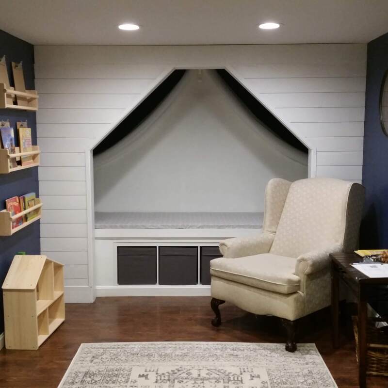 After - Library complete with reading nook, utilizing existing wingback chair church and upcycled flooring.